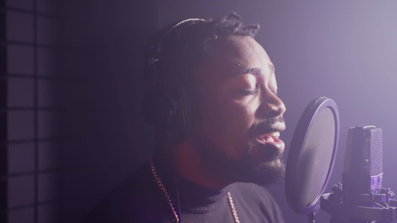 Man Singing into a Microphone in Recording Studio