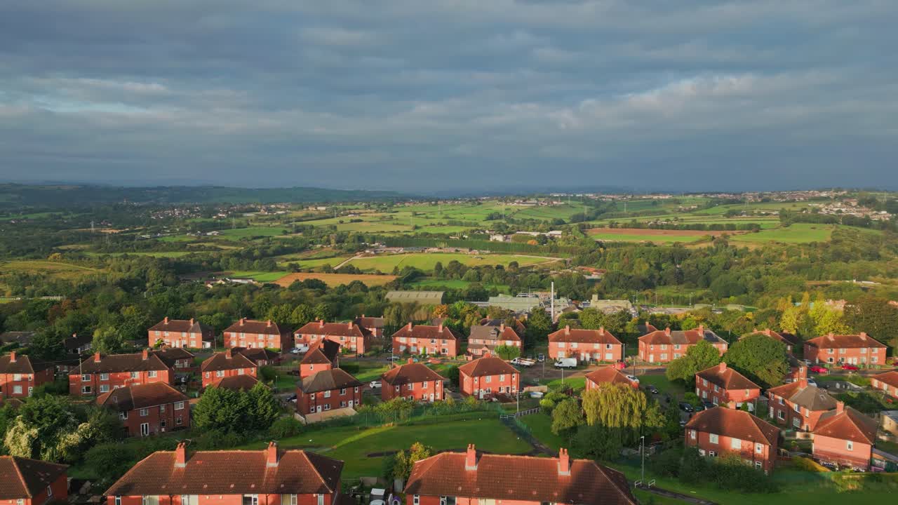 Yorkshire's urban life: Aerial view of red brick council housing in the morning light, with a vibrant community on the streets