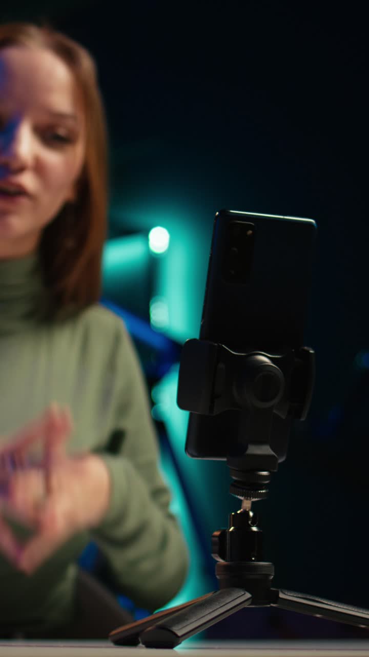 Giovane donna che fa video blog e gesticola mentre registra un video su smartphone