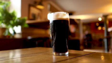 two pints of stout clinking in a pub