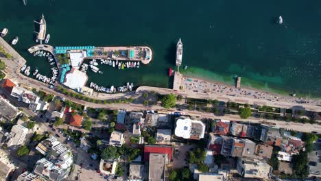 vista de arriba hacia abajo que muestra una colección de barcos y yates graciosamente atracados en el pintoresco muelle de saranda