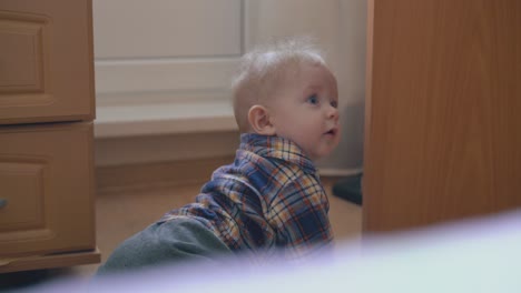 Un-Niño-Pequeño-Con-Camisa-Y-Pantalones-Se-Arrastra-Por-El-Suelo-En-Una-Habitación-Luminosa