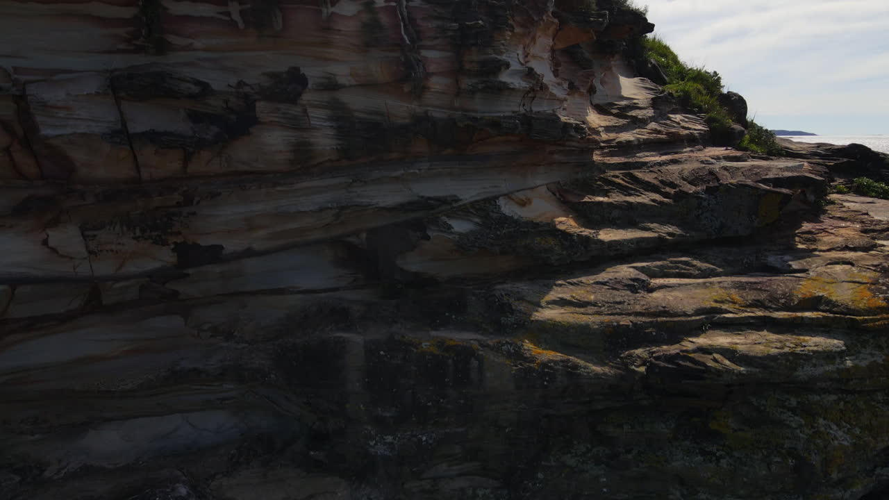 drone rozando rocas y luego ascendiendo a vistas al océano océano y mar almacen de videos