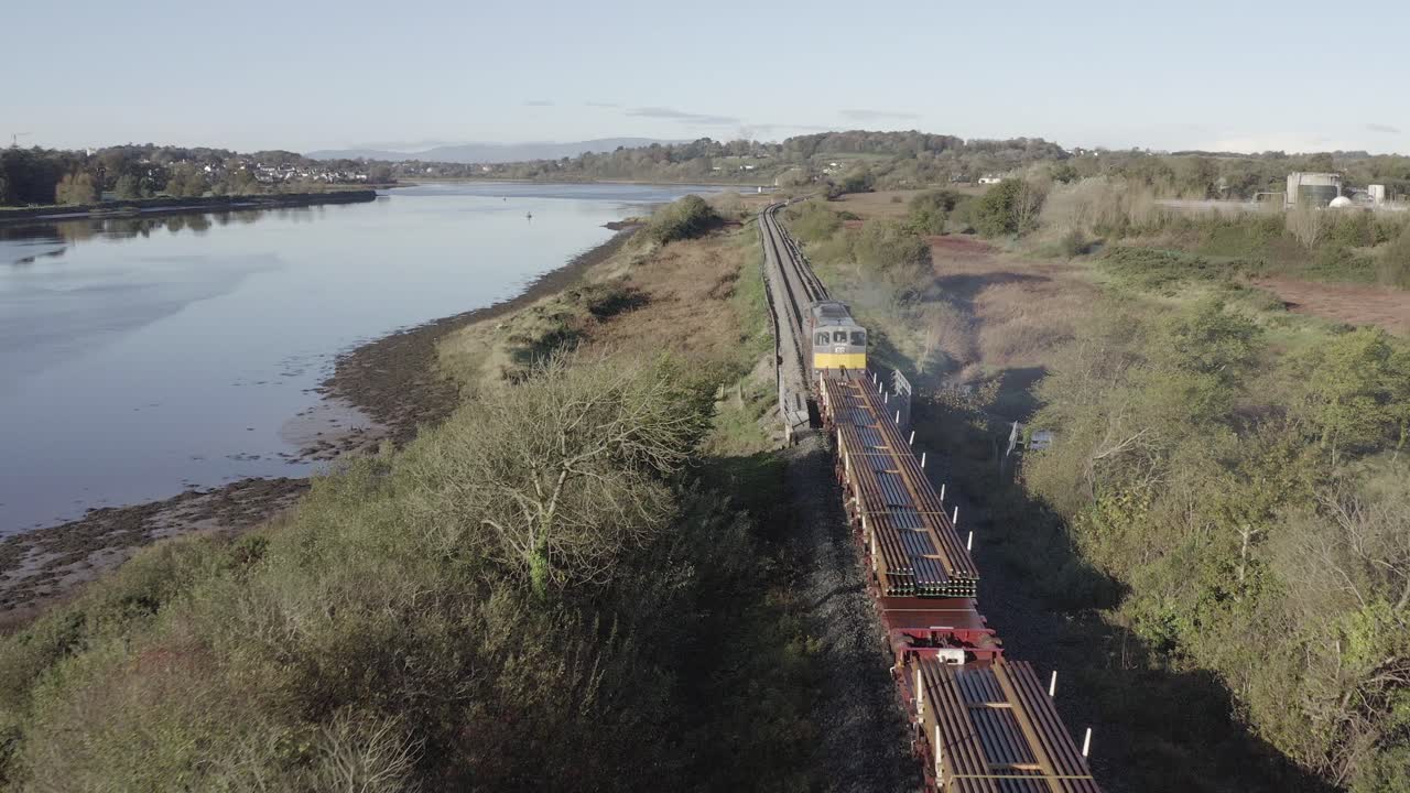 siguiente antena de tren de carga que transporta las vías del ferrocarril a lo largo del río