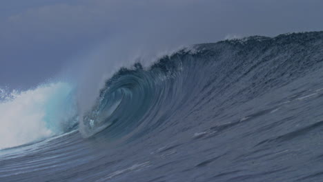 crashing ocean wave creates small picturesque barrel with heavy shoulder, cloudbreak fiji