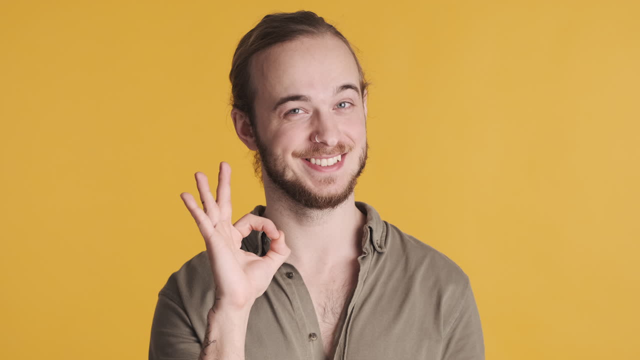 카우카시안 젊은이가 카메라 앞에서 한 몸짓을 하고 있습니다.