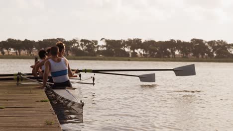 male rower team getting ready to practice rowing on lake