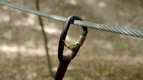 hand puts on auto lock carabiner on wire rope