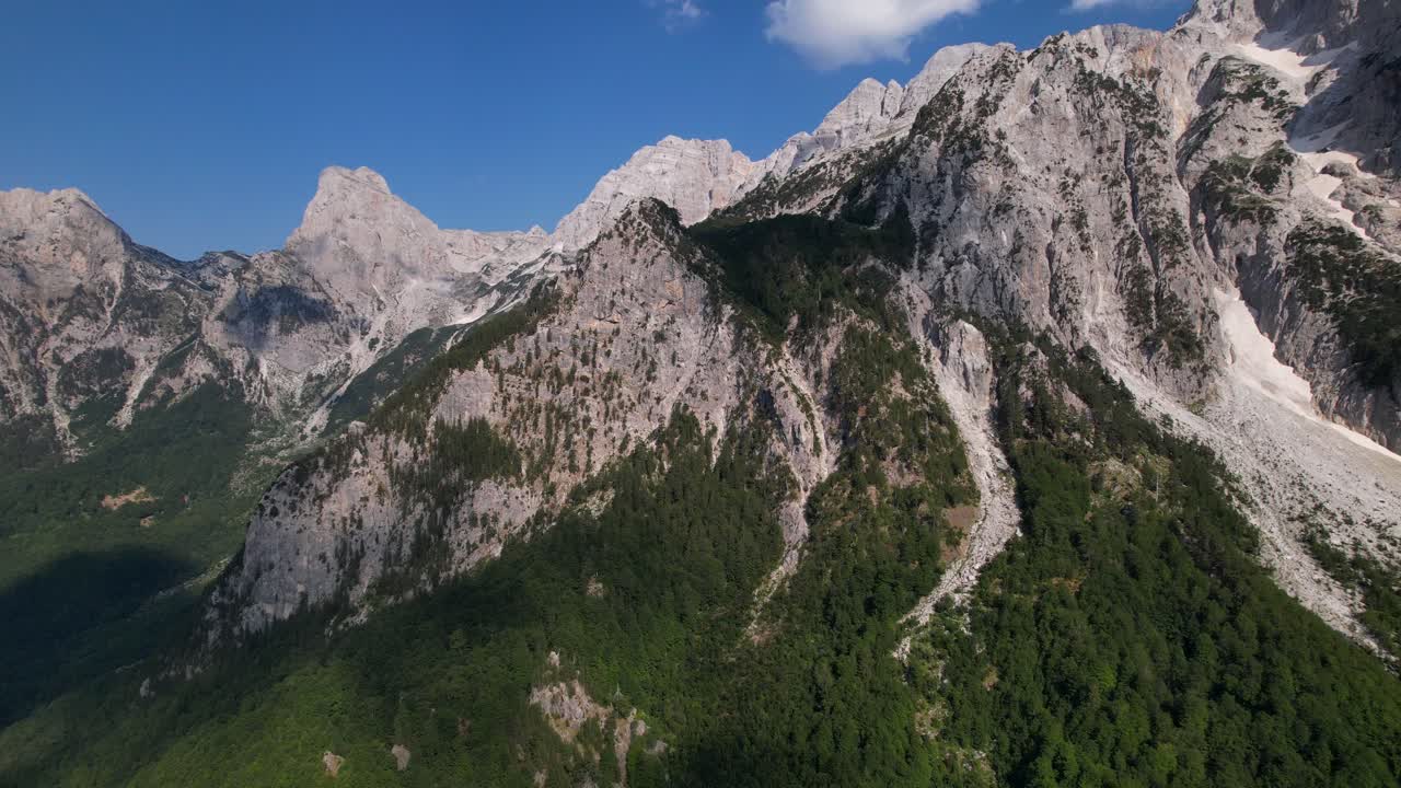 volando sobre los alpes en albania, hermosas montañas con picos altos y bosques verdes