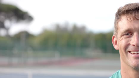 half portrait of happy caucasian male tennis player at outdoor tennis court, copy space, slow motion