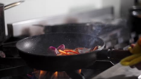 close up slow motion of vegetables fry in a pan in a restaurant kitchen.