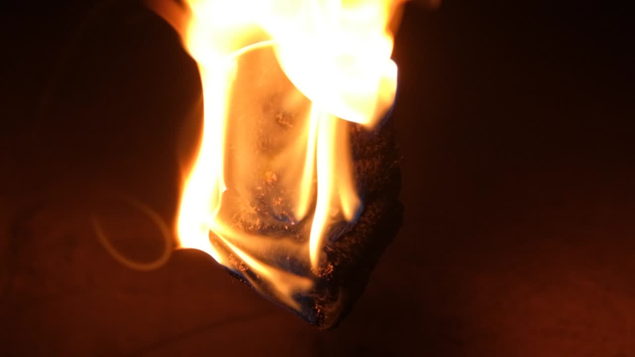 어둠 속에서 불꽃이 떨어지면서 느린 동작으로 타오르는 불덩어리 클로즈업