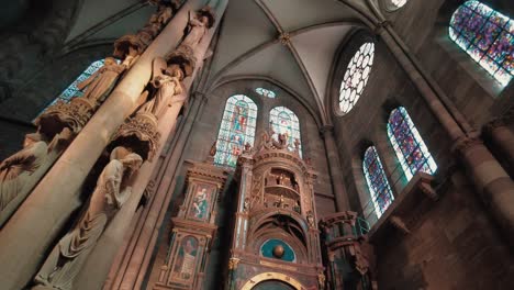 enorme pilar con estatuas angulares antes del reloj astronómico dentro de la catedral de notre dame de estrasburgo