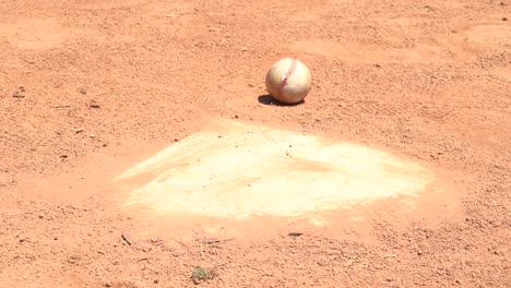 baseballs rolling across home plate