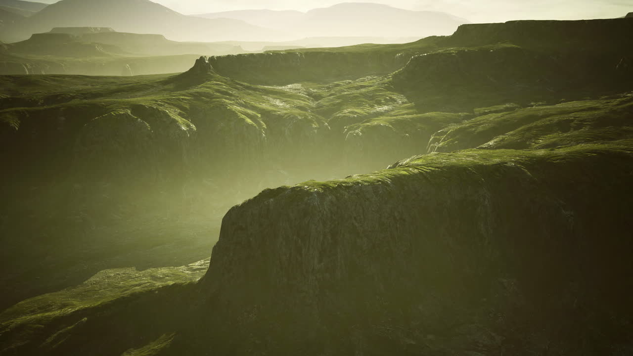 Sunrise over green hills and mountains in a serene landscape