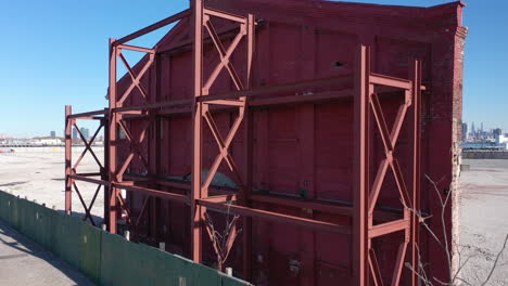 a low angle shot of an old building's red facade behind a green wooden fence