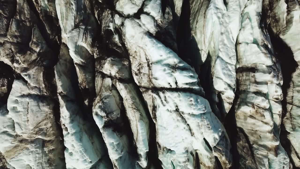 взгляд с вершины над текстурированным льдом исландского ледника в солнечный день