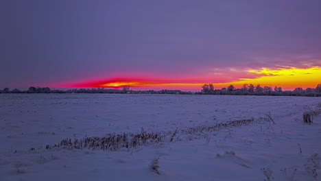 cielo de color rojo durante la puesta de sol durante el frío día de invierno en el campo agrícola - toma de lapso de tiempo