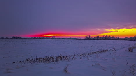 red colored sky during sunset time during cold winter day on farm field - time lapse shot