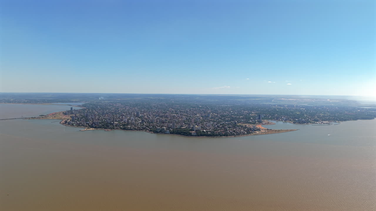 Discover Posadas, the capital of Misiones Province in northeastern Argentina, through a stunning panoramic aerial view bordered by the Paraná River.