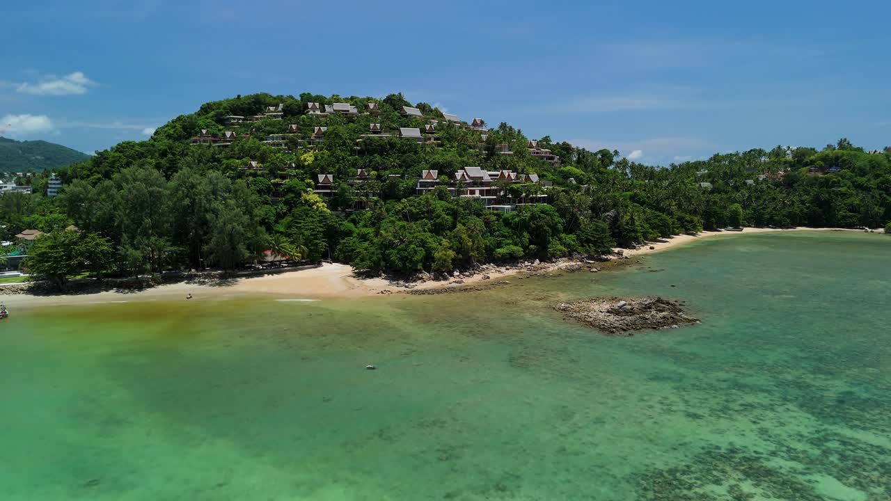 Aerial ascend approach glides toward hillside luxury resort villas on Bang Tao Beach, Phuket