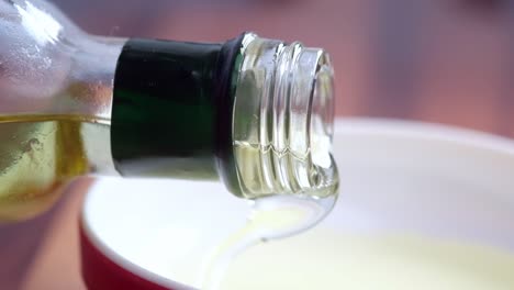 pouring oil into a bowl