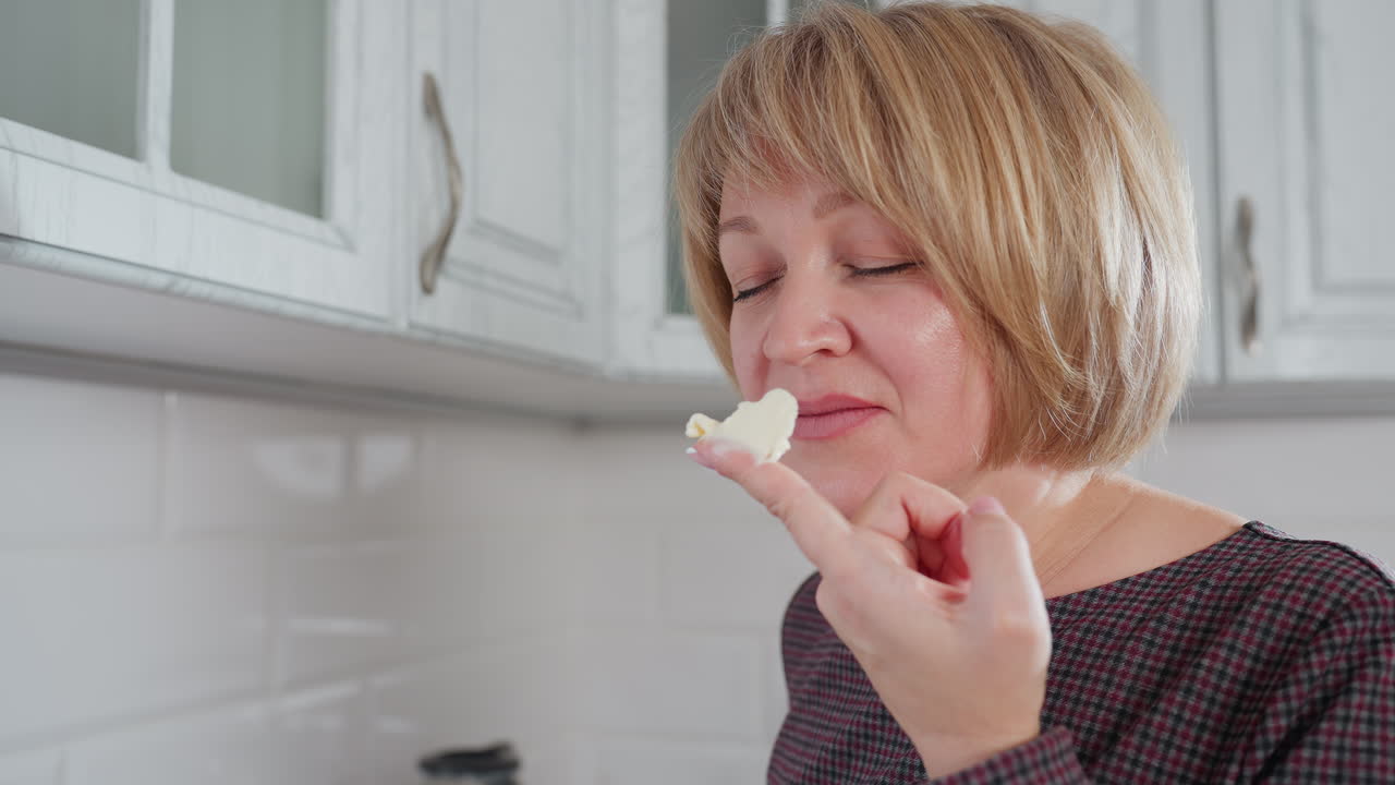 색 크림 버터를 손에 들고 만족스러운 표정으로 부에서 품질의 재료로 행복하고, 현대적인 가정 환경에서 요리 경험을 즐기고 있습니다.