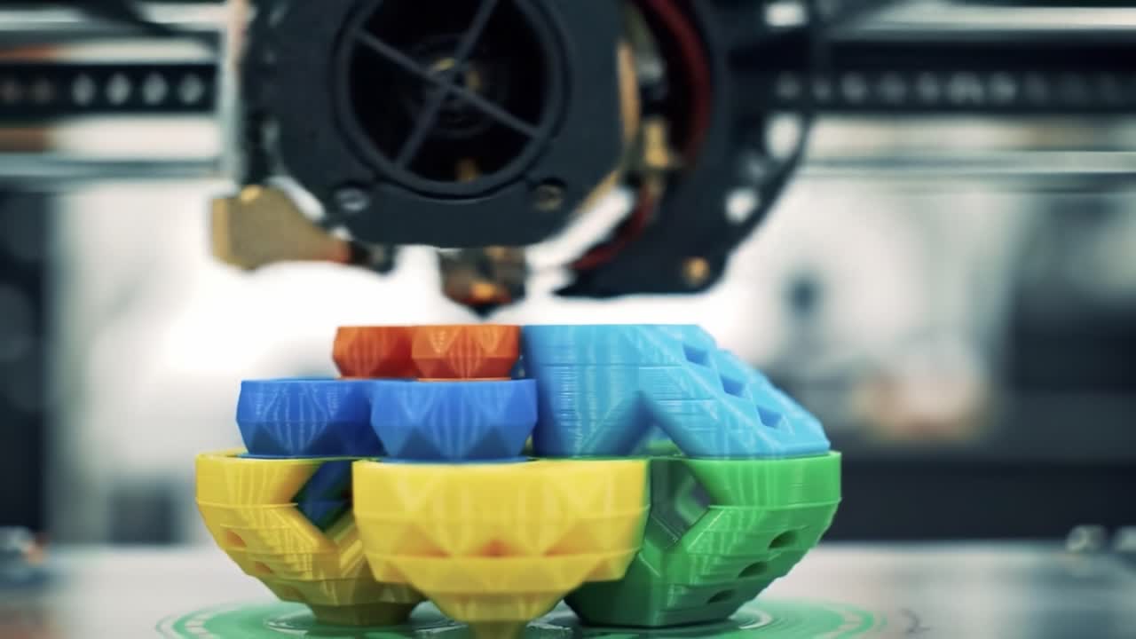 A Close-Up View of a 3D Printer Creating Multicolored Plastic Models with Precise Layering and Extrusion Techniques in a Modern Workshop Setting