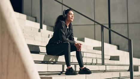 descanso de fitness, música y una mujer en las escaleras