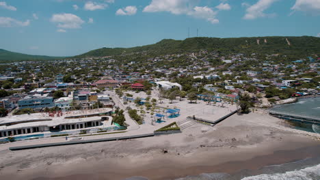 Fesselnde-Luftaufnahme:-Der-Strand-In-Der-Nähe-Des-Puerto-Columbia-Docks-Offenbart-Eine-Unglaubliche-Mischung-Aus-Urbanem-Charme-Und-Natürlicher-Schönheit