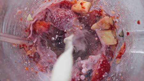 mezclador de flujo de leche fresca con bayas y frutas para hacer cócteles de vitaminas de cerca