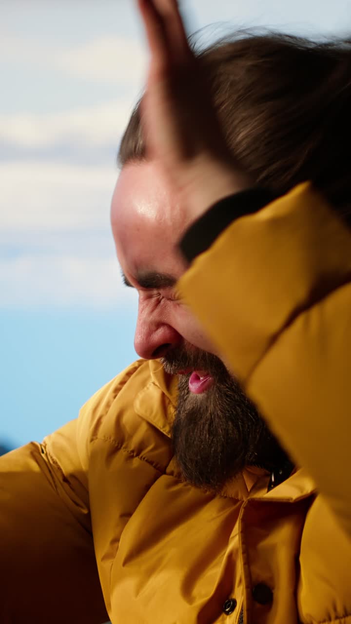 Man Struggling Against Strong Wind While Wearing Yellow Jacket