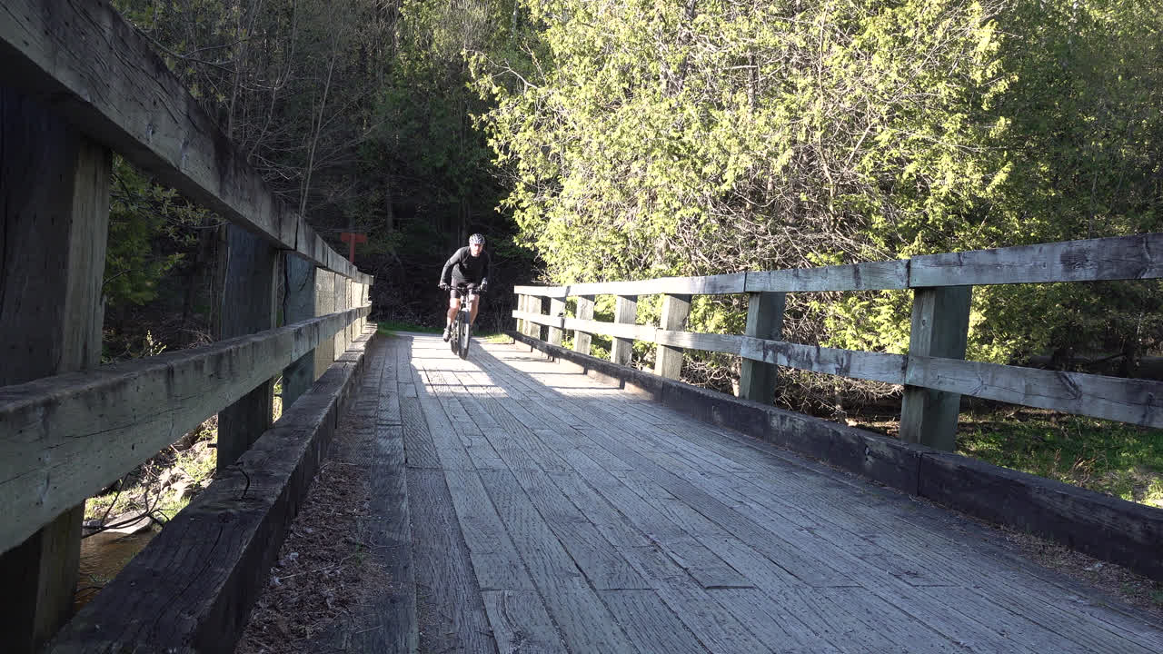 다리 위를 지나가는 자전거 타는 사람