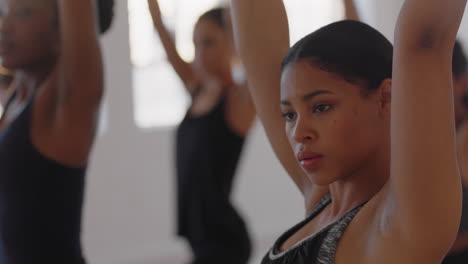 Hermosa-Mujer-De-Yoga-De-Raza-Mixta-Practicando-Meditación-De-Pose-Guerrera-Con-Un-Grupo-De-Mujeres-Multirraciales-Disfrutando-De-Un-Estilo-De-Vida-Saludable-Haciendo-Ejercicio-En-Un-Gimnasio-Al-Amanecer.