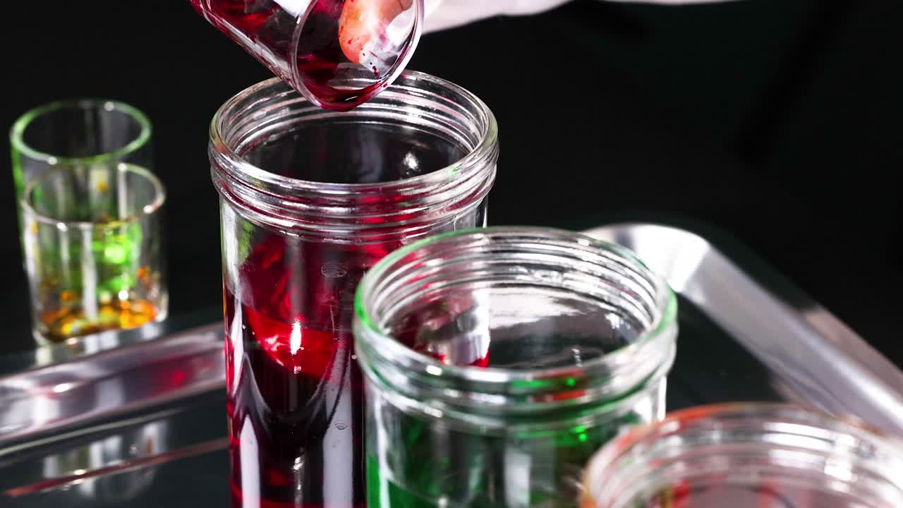 빨간 액체 가 유리 항아리 에 부어지고 있다