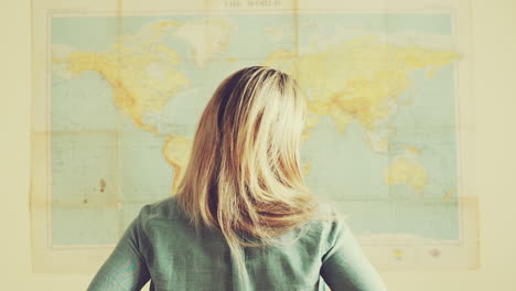 Una-Joven-Mujer-De-Viajes-Turísticos-Mira-El-Fondo-Del-Mapa-Mundial.