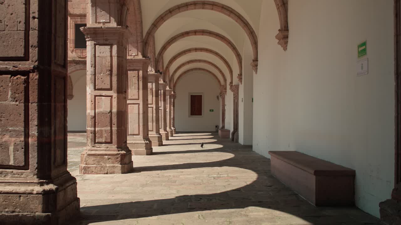 LENTO ZOOM OUT CON MOVIMENTO DELLA TELECAMERA SUI VICOLI DEL PALAZZO CLAVIJERO A MORELIA AL TRAMONTO