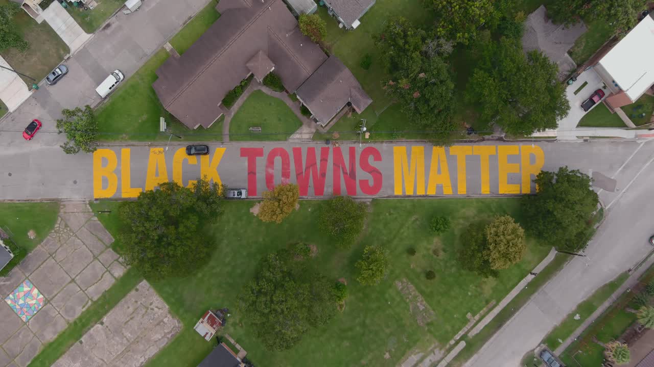 Bird eye view of a large "Black Towns Matter" sign painted on street in Houston Historical independence Heights district