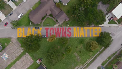 Bird-eye-view-of-a-large-"Black-Towns-Matter"-sign-painted-on-street-in-Houston-Historical-independence-Heights-district