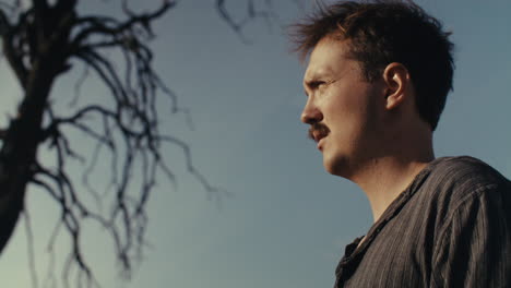 man with mustache in a rural setting