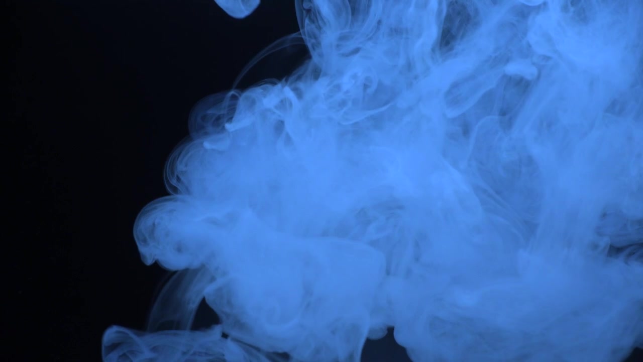 Fumo blu vorticoso in un ambiente scuro.