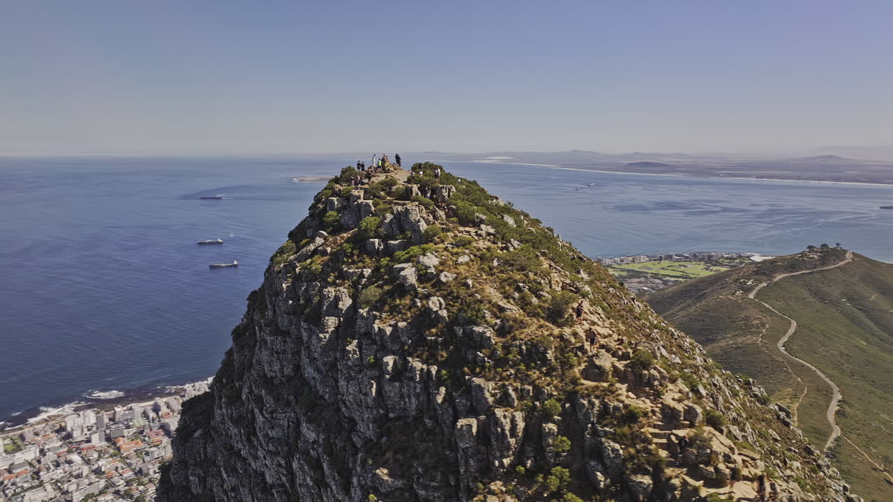 Cape Town South Africa Aerial v37 fly around the peak of Lion's head capturing panoramic views of Sea Point, Table Mountain, Camps Bay and deep blue ocean - Shot with Mavic 3 Pro Cine - Jan 11th 2024