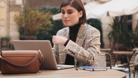 businesswoman working on laptop in cafe outdoor.