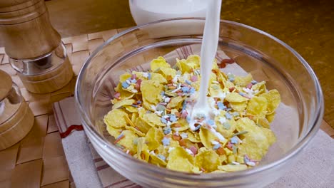 flocos de maíz amarillos crujientes en el cuenco para la mañana un delicioso desayuno con leche. cámara lenta con toma de seguimiento de rotación.