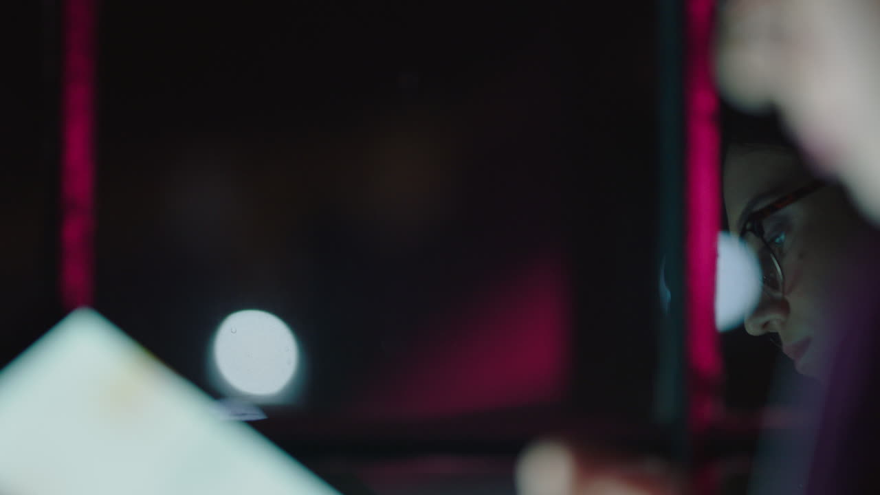 close up young caucasian business woman working late using digital tablet computer brainstorming creative ideas planning startup project deadline on mobile device touchscreen in office at night