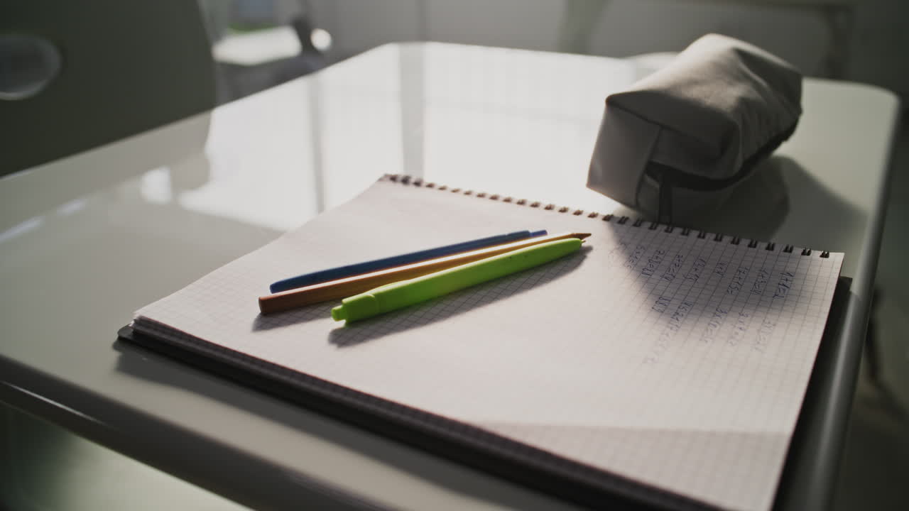 Close Up Shot of School Desk with Student School Supplies Pencil Case Pens and Pencils Notebooks