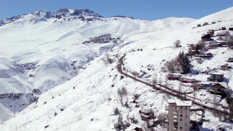 rising aerial shot showing the windy road from la parvas to farellones, chile