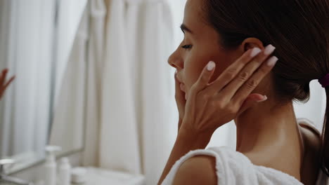 woman's skincare routine in the bathroom