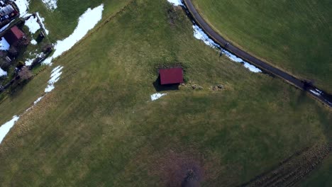 a little barn in the foreground, drone circling around it