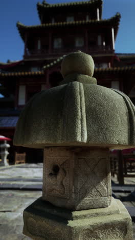 stone lantern in front of a chinese temple